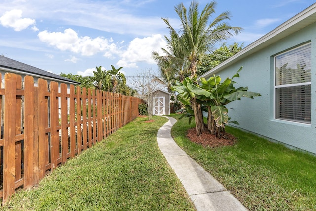 view of yard featuring a fenced backyard, a storage unit, and an outbuilding