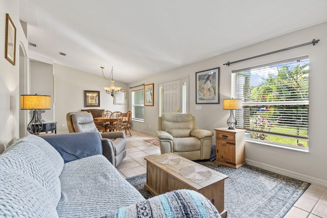 living area with baseboards, a chandelier, vaulted ceiling, and tile patterned floors