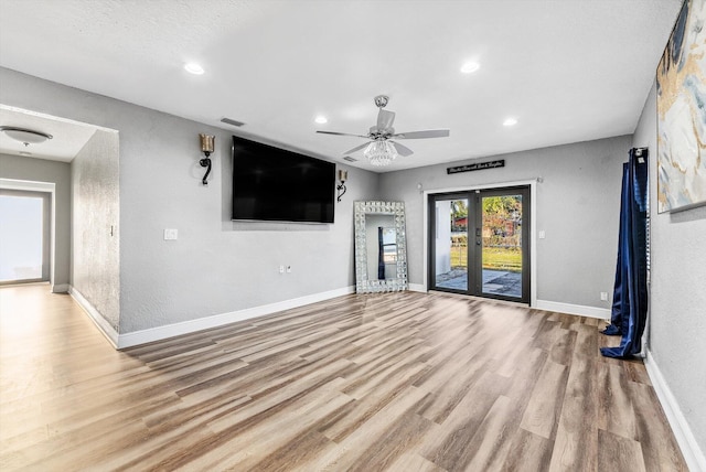 unfurnished living room with baseboards, visible vents, wood finished floors, french doors, and recessed lighting