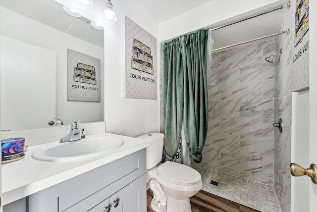 full bath with toilet, a shower stall, vanity, and wood finished floors