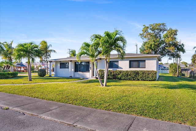 ranch-style home with a front lawn and stucco siding