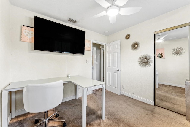 office area featuring light carpet, baseboards, visible vents, and a ceiling fan