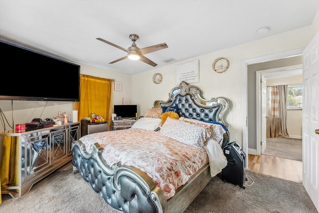 bedroom featuring ceiling fan, wood finished floors, visible vents, and baseboards