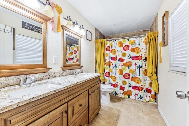 bathroom featuring curtained shower, a sink, toilet, and double vanity