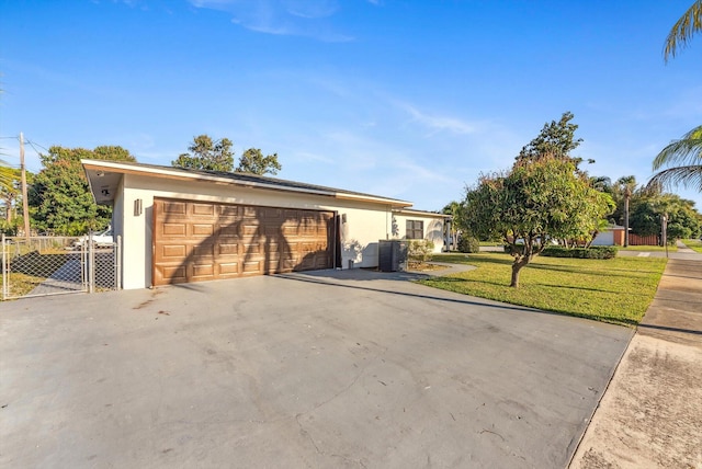 view of front of home featuring central air condition unit, a garage, fence, stucco siding, and a front lawn