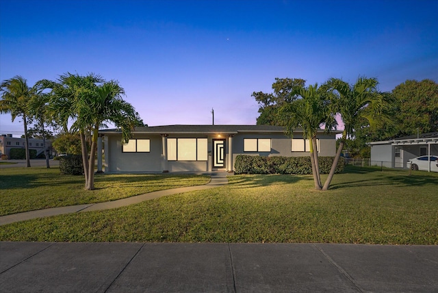 view of front facade featuring a front yard, fence, and stucco siding