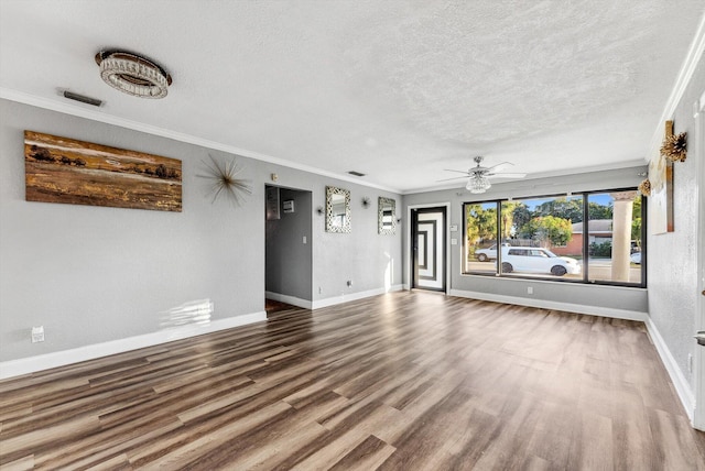 unfurnished living room featuring crown molding, a textured ceiling, baseboards, and wood finished floors