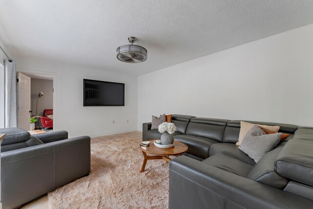 living room with a textured ceiling and baseboards