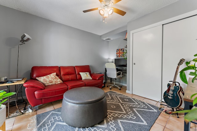 living room featuring a textured ceiling, ceiling fan, tile patterned flooring, and visible vents