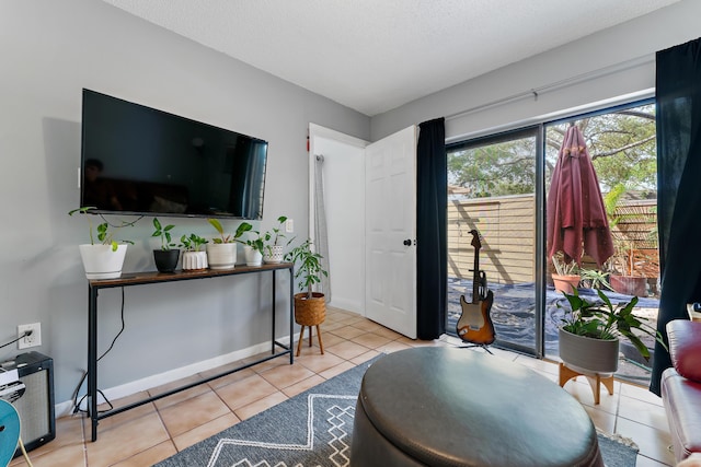 living room featuring baseboards, a textured ceiling, and tile patterned floors