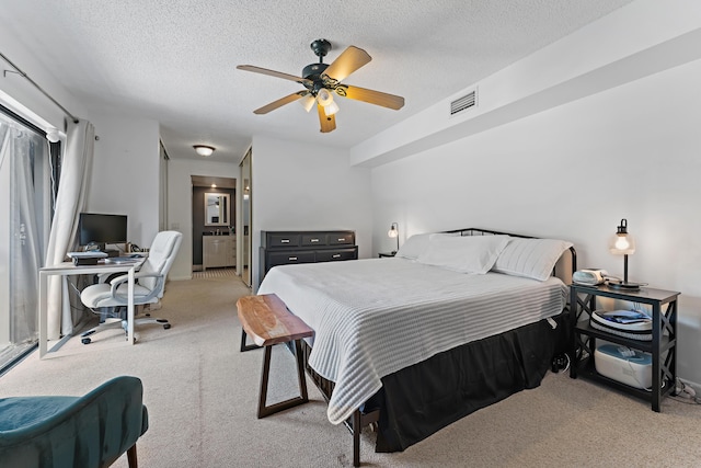 bedroom featuring visible vents, ceiling fan, ensuite bathroom, a textured ceiling, and carpet flooring