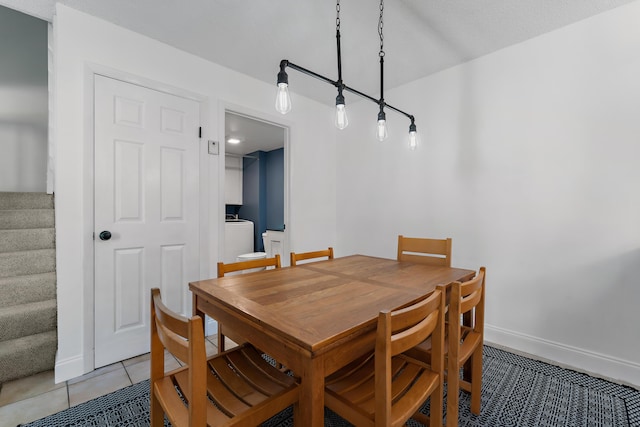 dining space featuring light tile patterned floors, baseboards, stairway, and washer / clothes dryer