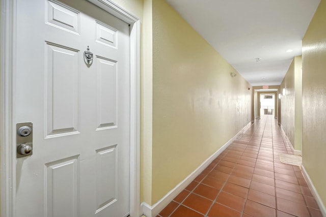 hallway featuring tile patterned floors and baseboards