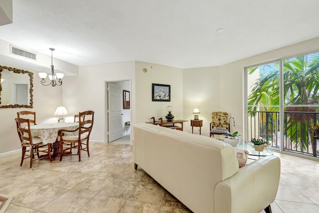 living room featuring baseboards, visible vents, and a chandelier