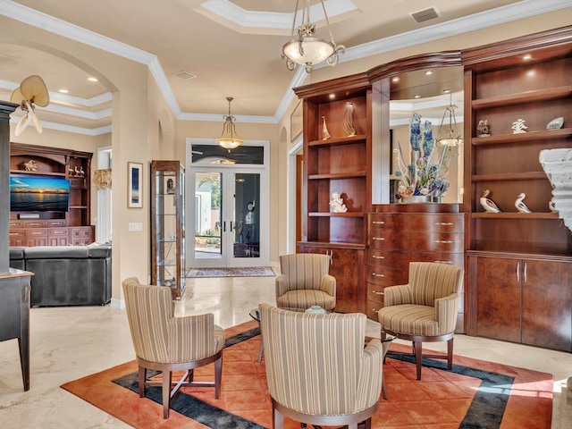 sitting room with a tray ceiling, visible vents, arched walkways, and crown molding