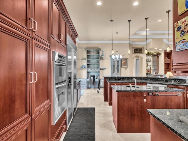 kitchen with dark stone counters, pendant lighting, a chandelier, and crown molding