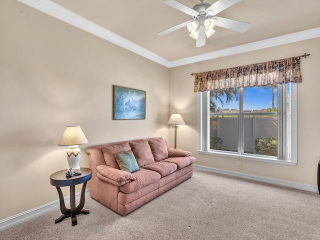 living area featuring carpet floors, baseboards, a ceiling fan, and ornamental molding