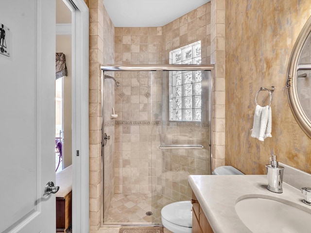 bathroom with toilet, a stall shower, and vanity