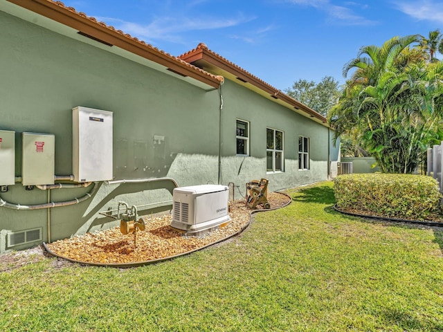 back of house with central AC unit, a lawn, a tiled roof, and stucco siding