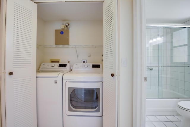 clothes washing area with laundry area, independent washer and dryer, and tile patterned floors