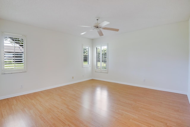 empty room featuring light wood-type flooring, baseboards, and a ceiling fan