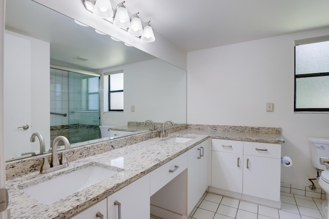 bathroom featuring a stall shower, tile patterned flooring, a sink, and toilet