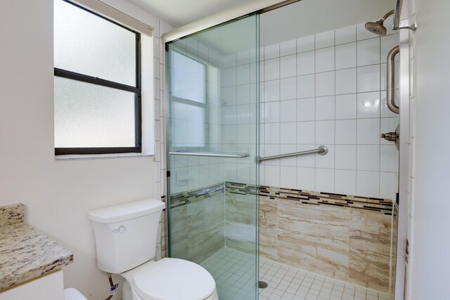 bathroom featuring toilet, a shower stall, and vanity