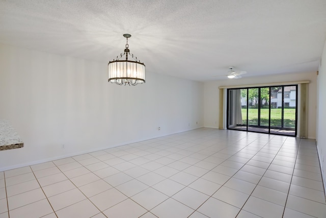 unfurnished room with light tile patterned floors, baseboards, a textured ceiling, and ceiling fan with notable chandelier