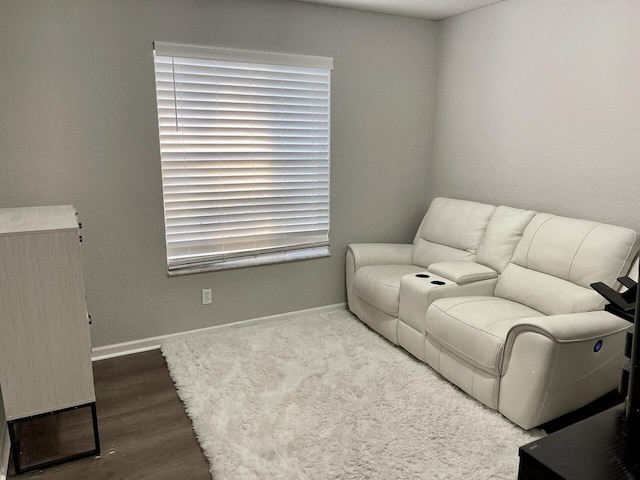 living area featuring baseboards and wood finished floors