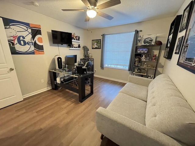 office area with a ceiling fan, a textured ceiling, baseboards, and wood finished floors