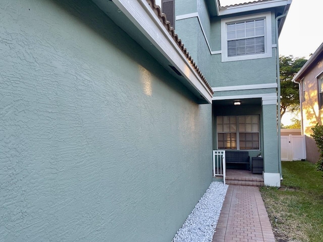 view of property exterior with covered porch and stucco siding