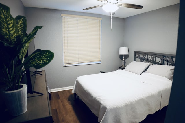 bedroom featuring ceiling fan, baseboards, and wood finished floors