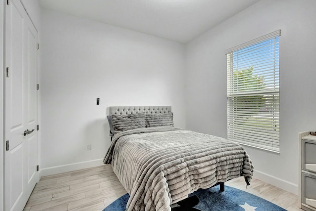 bedroom featuring baseboards and light wood finished floors