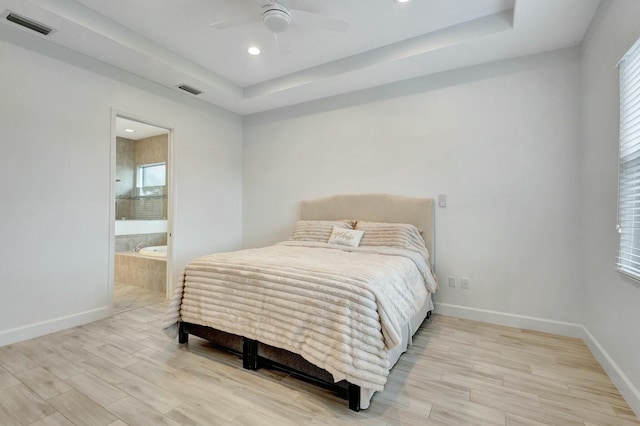 bedroom with a raised ceiling, visible vents, and baseboards