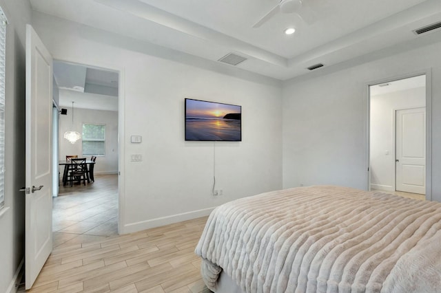 bedroom featuring light wood-type flooring, visible vents, and baseboards