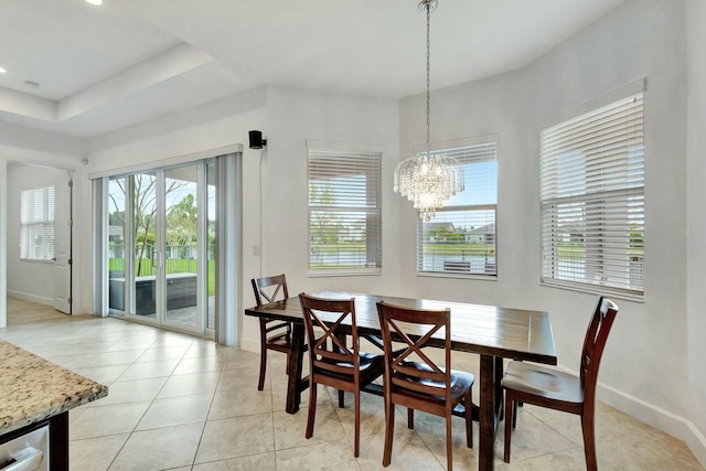 dining area featuring a healthy amount of sunlight, light tile patterned floors, baseboards, and a chandelier