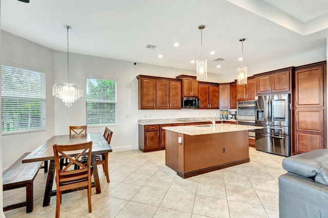 kitchen with visible vents, stainless steel appliances, light tile patterned floors, and a kitchen island with sink