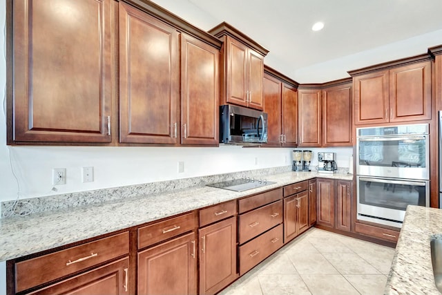 kitchen featuring light stone countertops, light tile patterned floors, stainless steel appliances, and recessed lighting