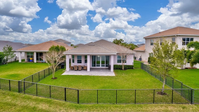 back of property with a tiled roof, a yard, and a fenced backyard