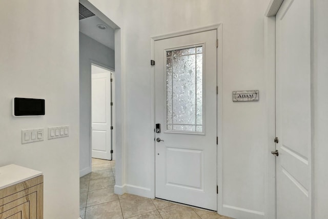 foyer featuring light tile patterned flooring and baseboards