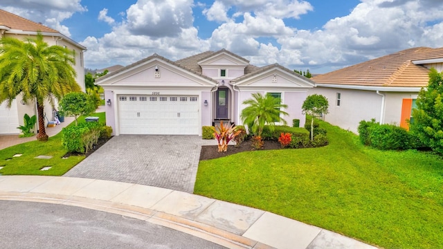 mediterranean / spanish-style house featuring a garage, a front yard, decorative driveway, and a tile roof