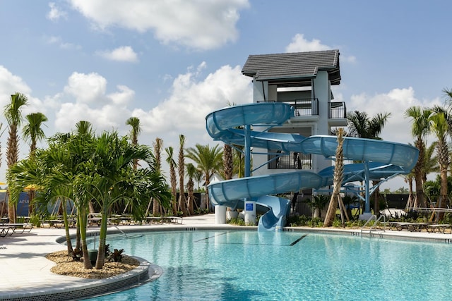 pool featuring a water slide and fence