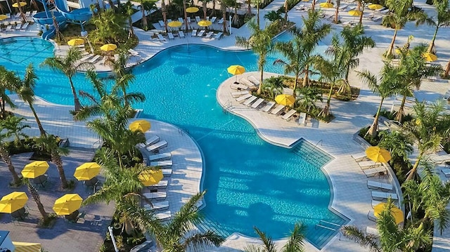 community pool with a patio area and a water slide