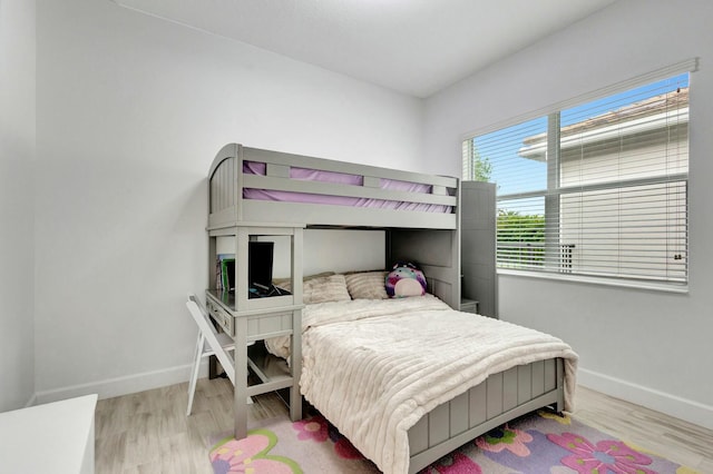 bedroom featuring baseboards and wood finished floors