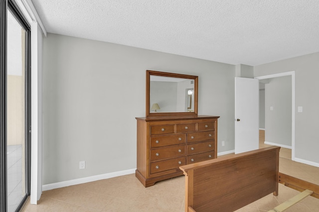 6620 Boca De Mar Dr Unit 105, Boca Raton, FL 33433 - bedroom featuring a textured ceiling, baseboards, and light tile patterned flooring