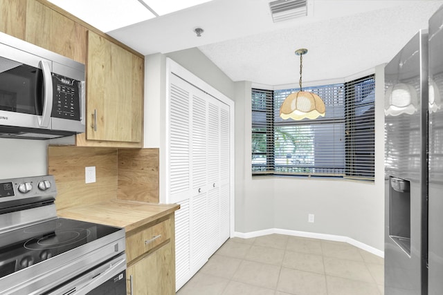 6620 Boca De Mar Dr Unit 105, Boca Raton, FL 33433 - kitchen featuring light brown cabinetry, visible vents, stainless steel appliances, decorative light fixtures, and baseboards