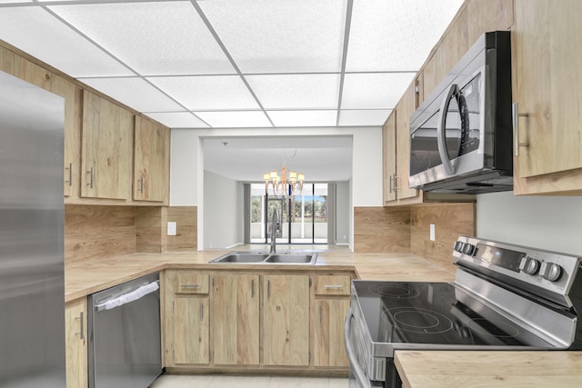 6620 Boca De Mar Dr Unit 105, Boca Raton, FL 33433 - kitchen featuring light brown cabinetry, tasteful backsplash, a sink, and stainless steel appliances
