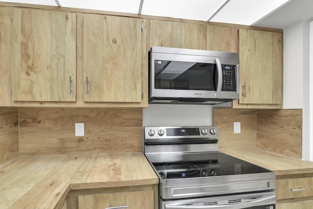 6620 Boca De Mar Dr Unit 105, Boca Raton, FL 33433 - kitchen with stainless steel appliances, wood counters, and light brown cabinetry