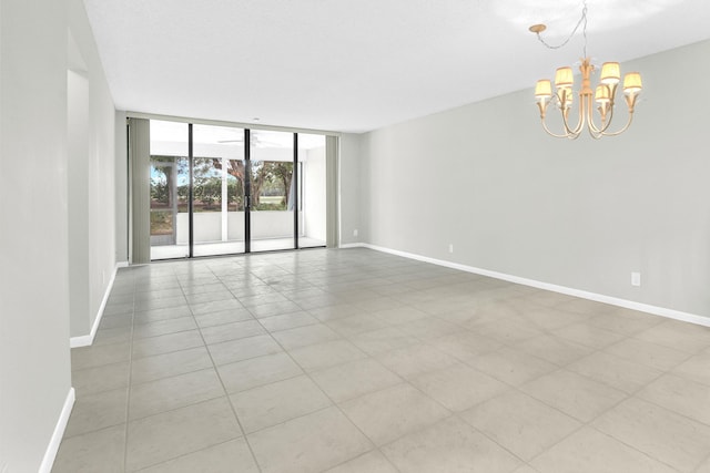 6620 Boca De Mar Dr Unit 105, Boca Raton, FL 33433 - empty room featuring baseboards, light tile patterned flooring, a notable chandelier, and floor to ceiling windows
