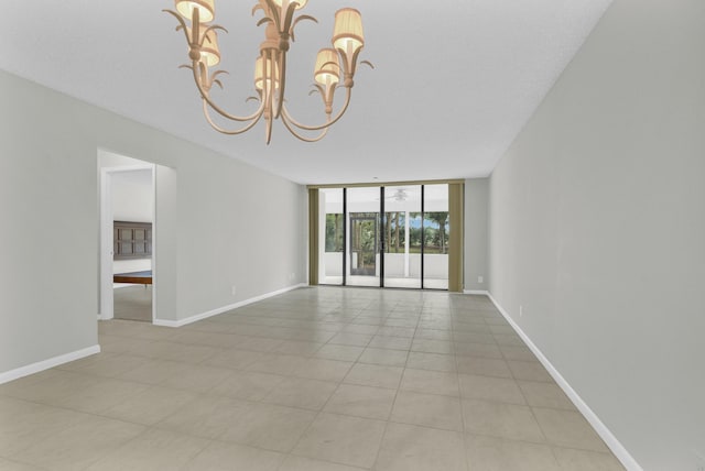 6620 Boca De Mar Dr Unit 105, Boca Raton, FL 33433 - spare room featuring floor to ceiling windows, baseboards, light tile patterned flooring, and an inviting chandelier